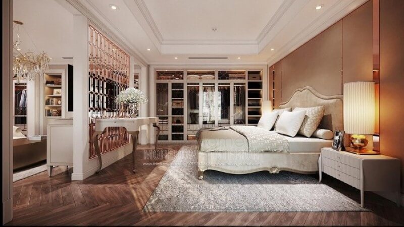 Sắp xếp nội thất phòng ngủ master ấn tượng với giường bọc tân cổ điển sang trọng, nệm ốp đầu giường tinh tế cùng thảm trải sàn hoa văn độc đáo. Thiết kế phòng ngủ biệt thự